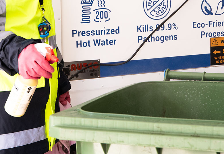 Deodorizing a wheelie bin by spraying an eco-friendly product.