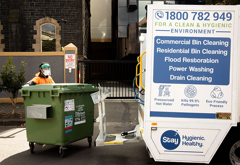 Victoria Hygiene staff moving the bin near the bin hygiene truck to clean, disinfect and deodorize it